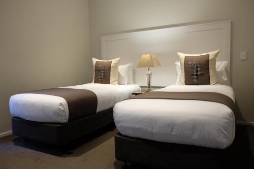 a hotel room with two beds and two lamps at West Meadows of Wanaka in Wanaka