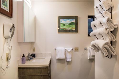 a bathroom with a sink and towels on the wall at Andril Fireplace Cottages in Pacific Grove