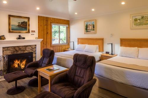 um quarto de hotel com duas camas e uma lareira em Andril Fireplace Cottages em Pacific Grove