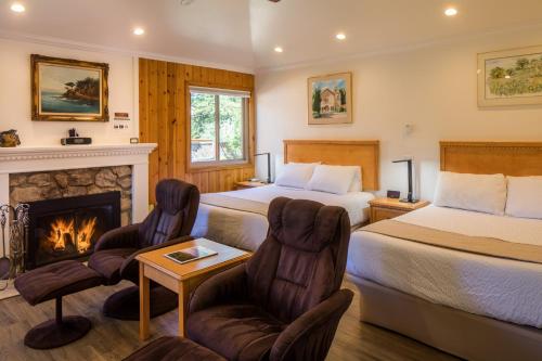 a hotel room with two beds and a fireplace at Andril Fireplace Cottages in Pacific Grove