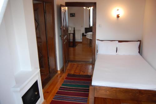 a small bedroom with a bed and a television at Kazasovata Guest House in Tryavna