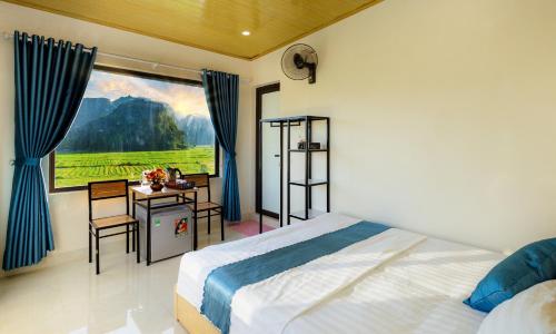 a bedroom with a bed and a desk and a window at Cherry homestay in Ninh Binh