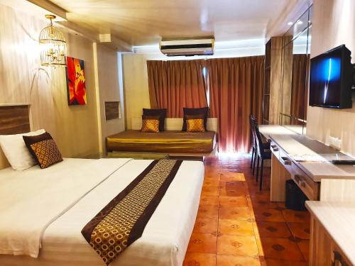 a hotel room with a large bed and a couch at The Montana Lodge-Sathorn in Bangkok