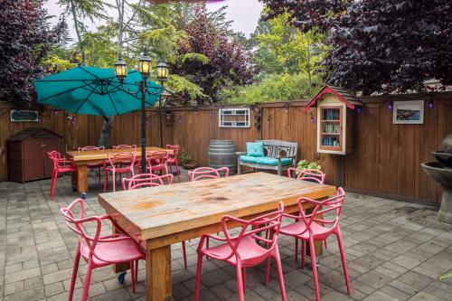 a patio with a wooden table and chairs and an umbrella at Andril Fireplace Cottages in Pacific Grove