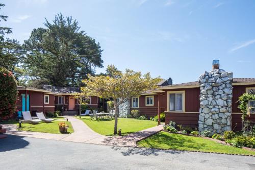 a row of houses with a yard with a tree at Andril Fireplace Cottages in Pacific Grove
