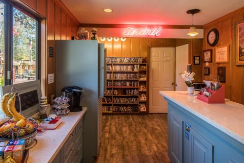 a kitchen with a refrigerator and a book shelf at Andril Fireplace Cottages in Pacific Grove