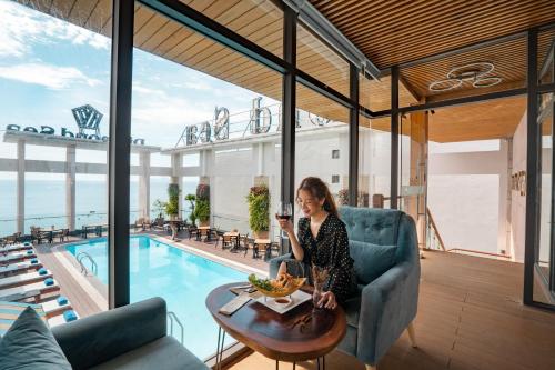 a woman sitting in a chair in front of a pool at Diamond Sea Hotel in Da Nang
