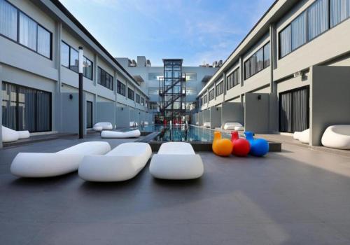 a group of white chairs sitting in front of a building at S Ratchada Leisure Hotel in Bangkok