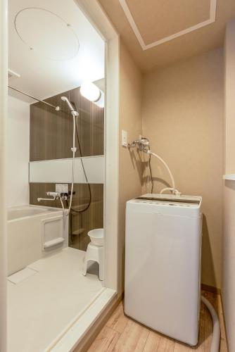 a bathroom with a shower and a toilet and a sink at VILLA KOSHIDO KOTONI annex in Sapporo