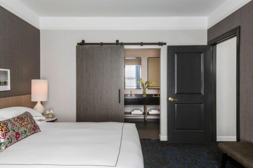 a bedroom with a white bed and a black door at Kimpton Gray Hotel Chicago by IHG in Chicago