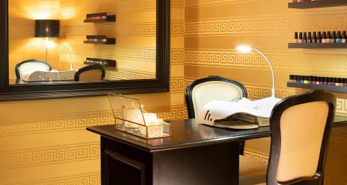 a vanity with a mirror and a chair in a salon at Victor's Residenz-Hotel Schloss Berg in Nennig