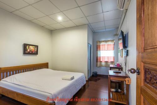 Dormitorio pequeño con cama y mesa en บ้านพักศรีสมบูรณ์ เชียงคาน, en Chiang Khan