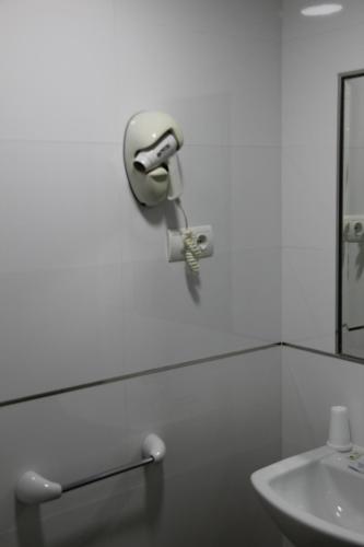 a white bathroom with a sink and a mirror at Hostal Maribel in Almería