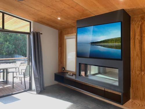 TV de pantalla plana en la pared de la sala de estar. en BIG4 Yarra Valley Park Lane Holiday Park en Healesville