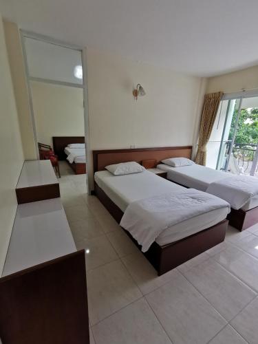 a hotel room with two beds and a mirror at Subhamitra Hotel Hua Hin-SHA Certified in Hua Hin