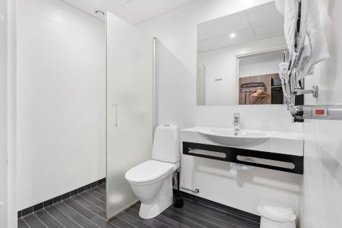 a white bathroom with a toilet and a sink at Best Western Hotel Corallen in Oskarshamn