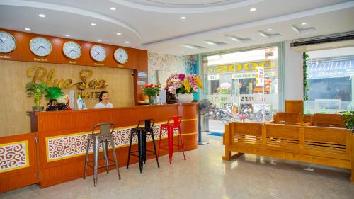 a restaurant with a woman sitting at a counter and chairs at Blue Sea Hotel Quy Nhơn - 02 Trần Độc in Quy Nhon