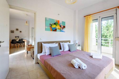 1 dormitorio con 1 cama grande y 2 toallas. en Villa MALENA Nature and Sea View, en Psari Forada
