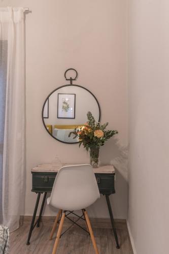 a table with a white chair and a mirror at Casa Leone, cosy apartment overlooking the square in Spílion