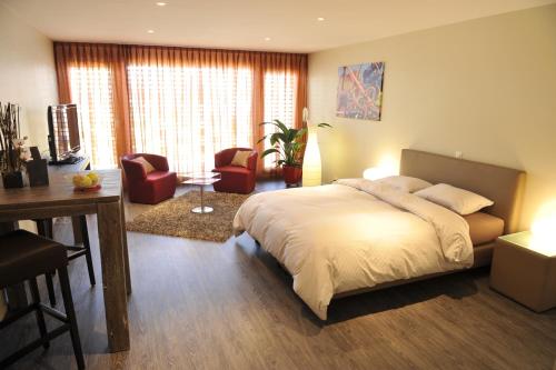 a bedroom with a bed and a desk and chairs at Cave Beetschen in Bursins