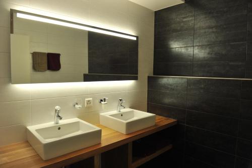 a bathroom with two sinks and a mirror at Cave Beetschen in Bursins