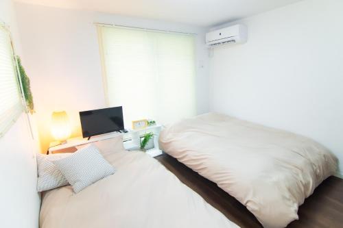Ένα ή περισσότερα κρεβάτια σε δωμάτιο στο Base Hanegi Apartment