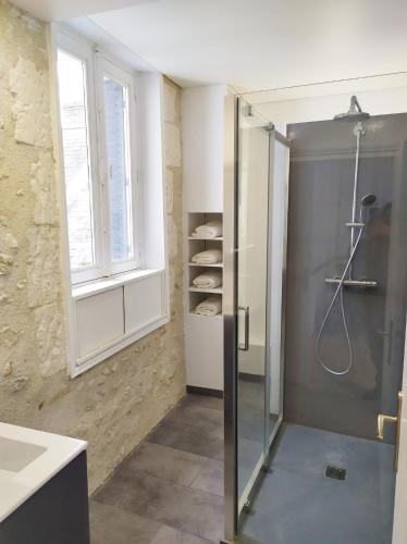 une salle de bain avec une douche avec une porte vitrée dans l'établissement Le Huis Clos, à Amboise