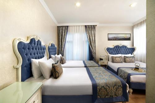 two beds in a room with blue and white at Ayasultan Hotel in Istanbul
