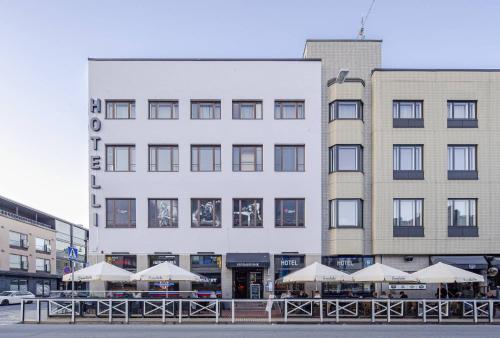 un edificio con sombrillas blancas delante en Hotel Seurahuone Riihimäki en Riihimäki