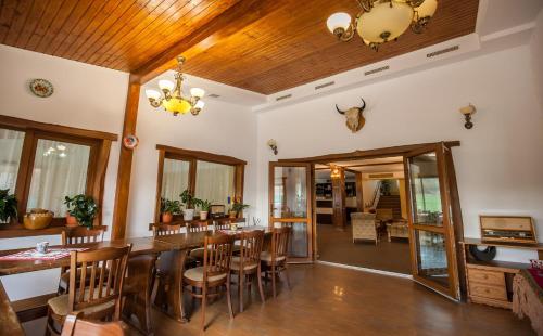 a dining room with a large wooden table and chairs at Pensiunea Victoria in Şuţu