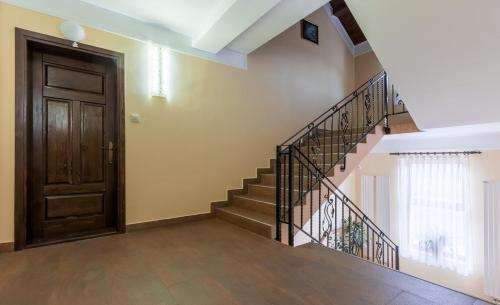a staircase in a house with a wooden door at Pensiunea Victoria in Şuţu
