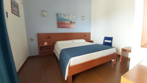 マルゲリータ・ディ・サヴォイアにあるResidence Bandiera Giallaのベッドルーム1室(大型ベッド1台、青と白のシーツ付)