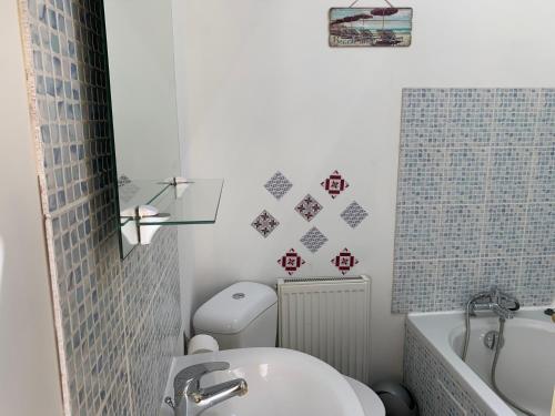 a bathroom with a toilet and a tub and a sink at Gite L'Eglantier in Luçon