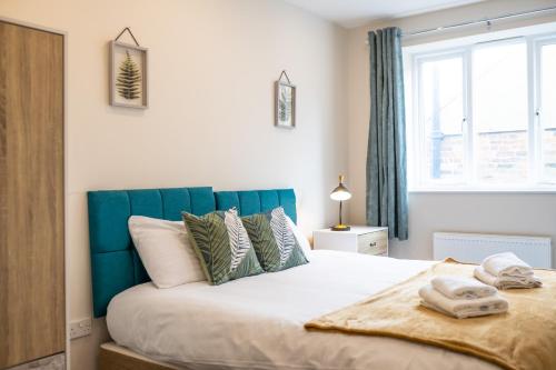 South Quay Penthouse - 2 Bed في غريت يورماوث: غرفة نوم مع سرير كبير مع اللوح الأمامي الأزرق