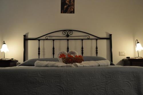 a bed with a black frame with a basket of flowers on it at B&B Villa Rosanna in Fasano