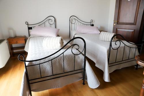 - 2 lits avec des draps et des oreillers blancs dans une chambre dans l'établissement Agriturismo Borgo Borromeo, à Rubano