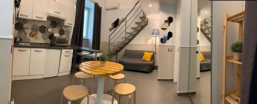 Una cocina y una sala de estar con mesa y sillas. en Little Dream Residenza - Napoli, en Nápoles
