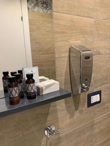 estante con botellas y espejo en una habitación en Little Dream Residenza - Napoli, en Nápoles