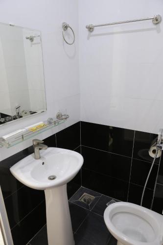 a bathroom with a white sink and a toilet at Thanh Trang Hotel in Con Dao
