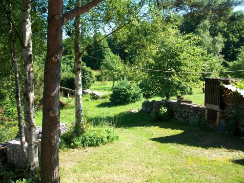 a garden with a stone wall and a bench at Kelluka Holiday House in Pärispea