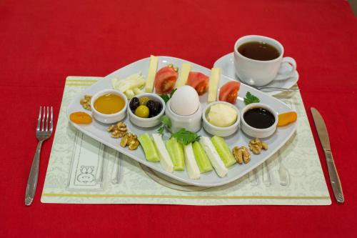 une assiette d’aliments avec des œufs et d’autres aliments et une tasse de café dans l'établissement İHVA HOTEL PİERRELOTİ, à Istanbul