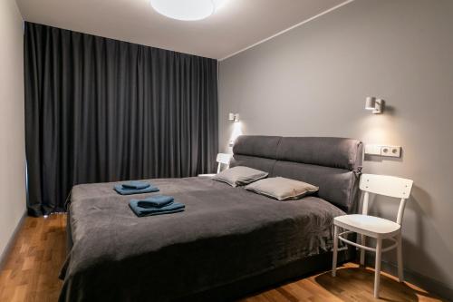 a bedroom with a large bed and a chair at Brand New, Family-friendly with a great location - Moon Apartment in Ventspils