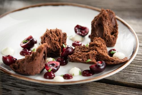 a plate of chocolate brownies and cherries on a table at Hotel Wisła Premium in Wisła