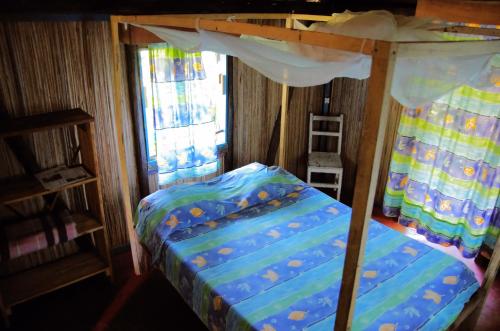 a bedroom with a bunk bed with a canopy at Hotel le Lagon in Foulpointe