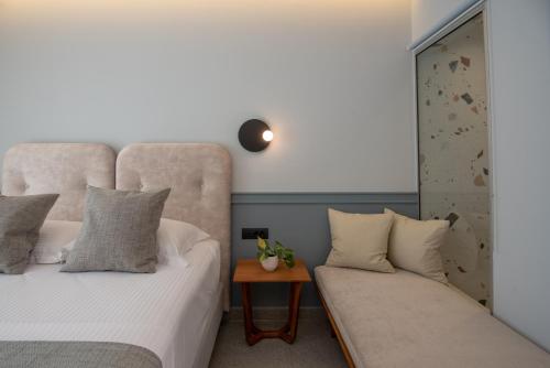 a bedroom with two beds and a couch at Charisma Boutique Hotel in Parga