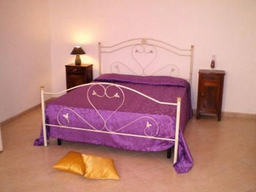 a purple bed in a room with two night stands at B&B Pacheco in Paceco