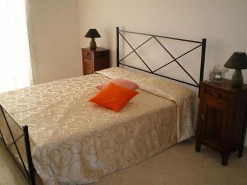 Schlafzimmer mit einem Bett mit orangefarbenem Kissen in der Unterkunft B&B Pacheco in Paceco
