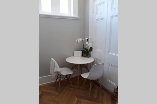 a small table and chairs in a room with a door at Gawler Heritage Accommodation in Gawler