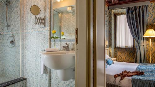 een badkamer met een wastafel, een douche en een bed bij Residenza Canova Tadolini - Guesthouse in Rome