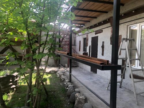 a porch of a house with a bench and a ladder at Master's House Dayan in Yerevan